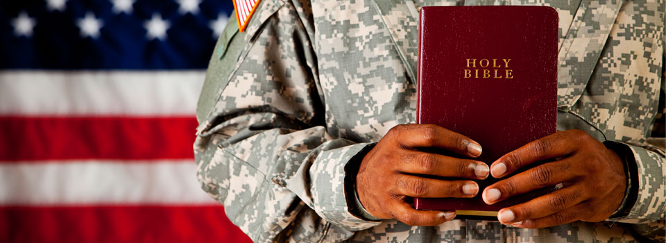 A soldier holding a book in his hands.